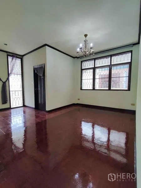 独立式住宅 出租在Khlong Toei, Bangkok - 卧室配吊灯与亮面木地板，转角窗带防盗格。