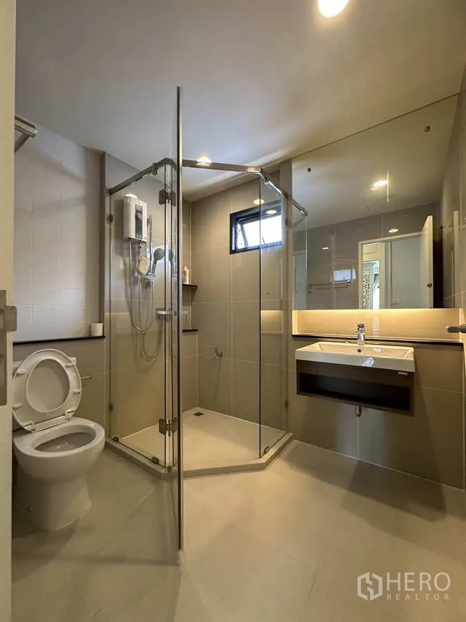 Detached House for rent or sale in Lam Luk Ka, Pathum Thani - Bathroom with glass shower enclosure, vanity and toilet.