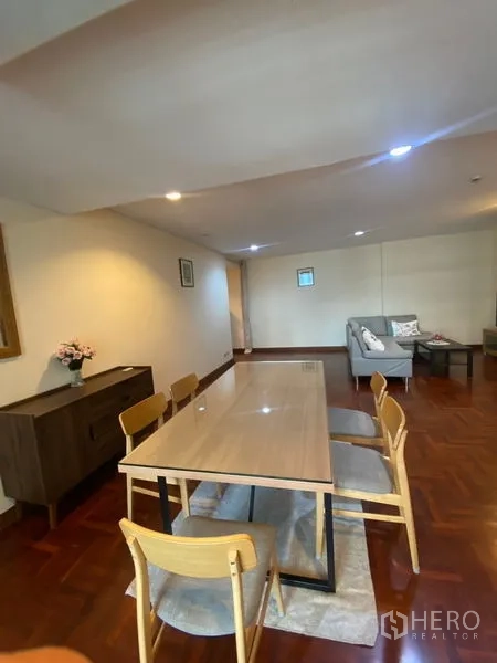 公寓 出租在Pathum Wan, Bangkok - 从餐区望向客厅，六人餐桌置于地毯之上。