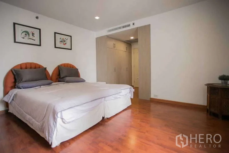 Condominium for rent or sale in Watthana, Bangkok - Second bedroom alternate angle showing wardrobes and wood floors.