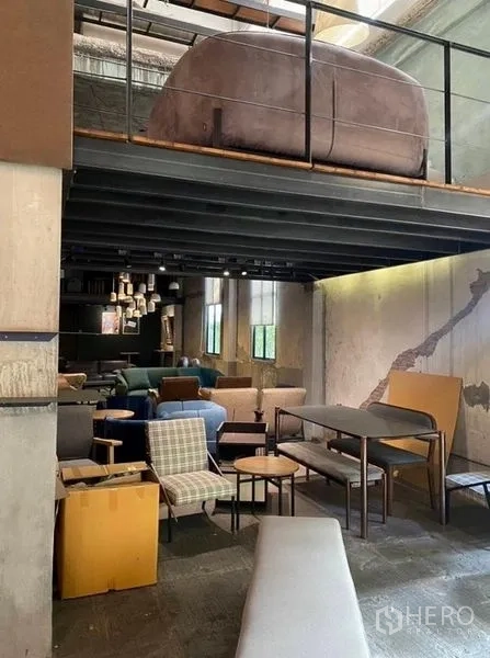 零售空间 出租在Bang Na, Bangkok - 夹层下方的一层座位区，裸露混凝土墙面