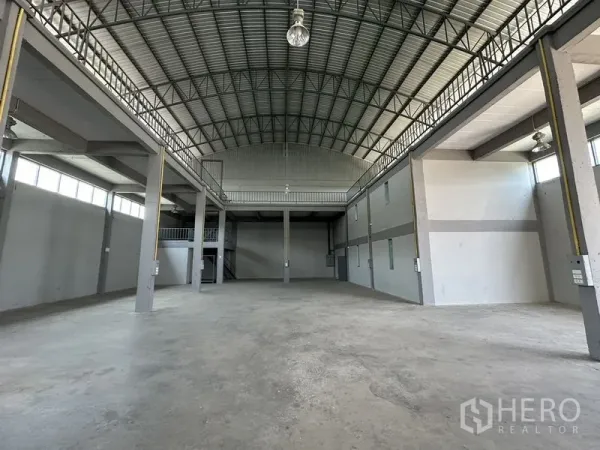 Factory for rent in Lam Luk Ka, Pathum Thani - Spacious factory interior showing mezzanine, skylights, and open production area.