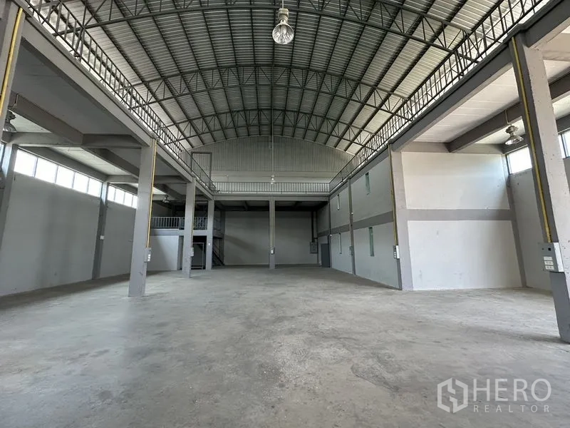 Factory for rent in Lam Luk Ka, Pathum Thani - Spacious factory interior showing mezzanine, skylights, and open production area.