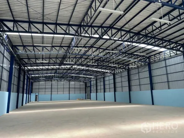 Warehouse for rent in Lat Krabang, Bangkok - Spacious high-clearance warehouse interior with steel truss roof, skylights and smooth concrete flooring.