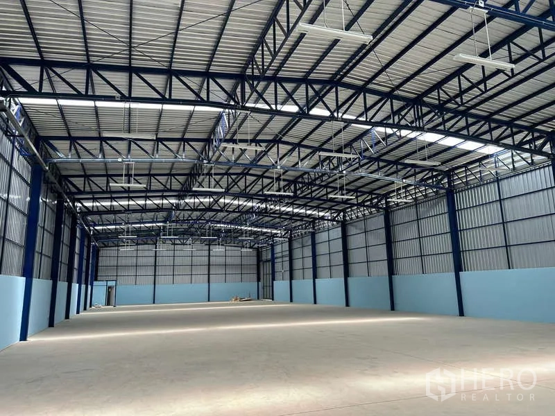 Warehouse for rent in Lat Krabang, Bangkok - Spacious high-clearance warehouse interior with steel truss roof, skylights and smooth concrete flooring.