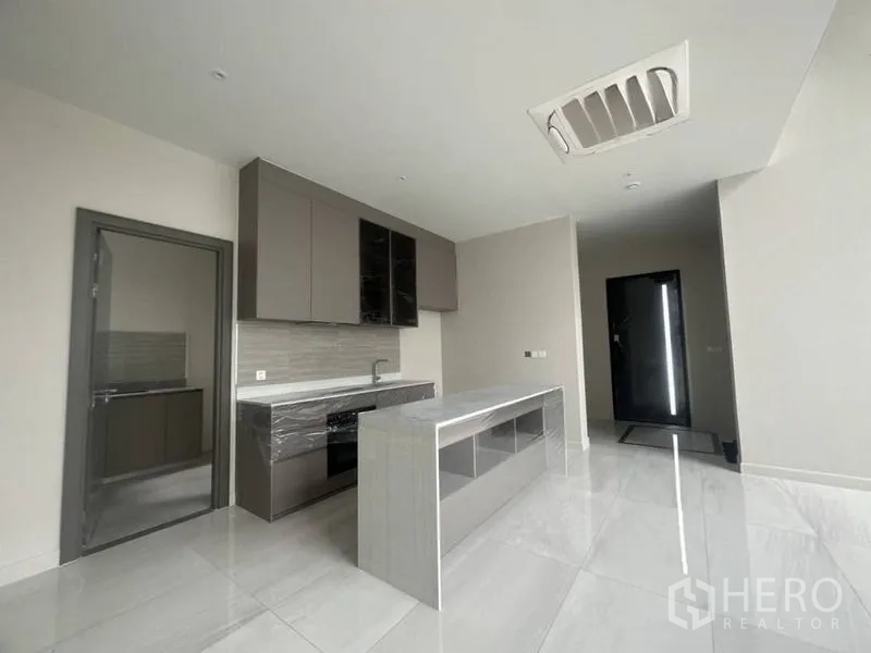 Detached House for rent - Sleek built-in kitchen with island, upper cabinets and door to service area.