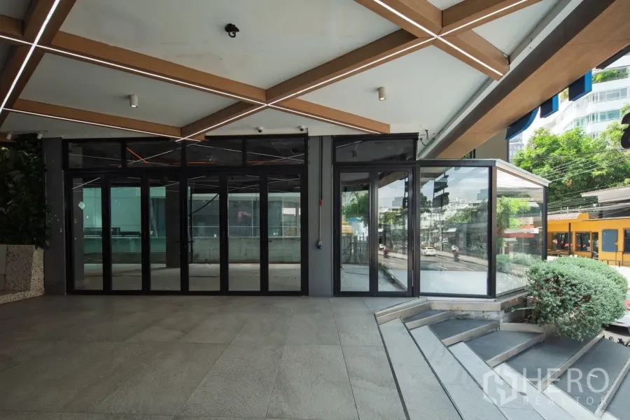 Retail Space for rent in Khlong Toei, Bangkok - Street-facing glass storefront with folding doors, canopy lighting and steps near BTS Thong Lo.