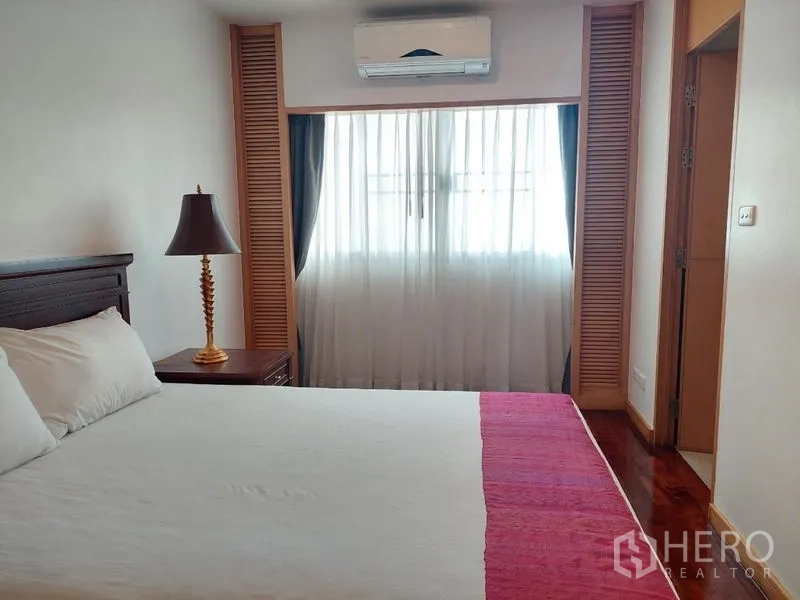 Apartment for rent - Cozy bedroom with bed, sheer curtained window and air conditioning.