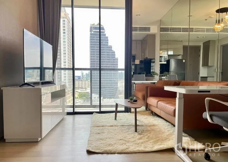 公寓 出租在Ratchathewi, Bangkok - 落地窗客厅，观赏天际线，配电视柜与地毯沙发。