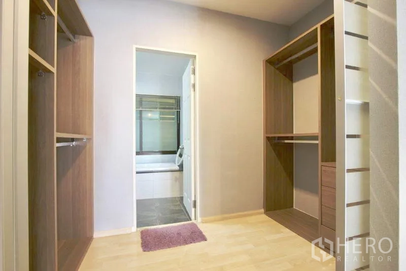 Townhouse for sale in Suan Luang, Bangkok - Walk-in closet with open wardrobes leading to ensuite bathroom.