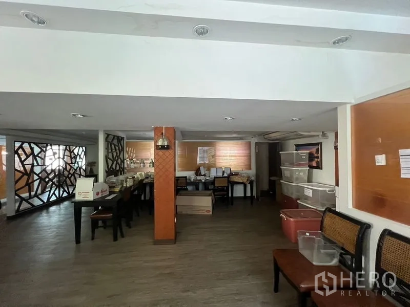 Retail Space for rent or sale in Khlong Toei, Bangkok - Multipurpose room arranged for storage with tables and plastic bins.