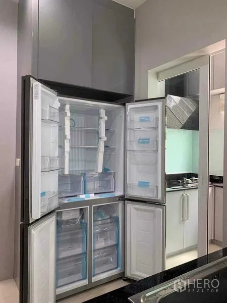 Detached House for rent in Bang Khen, Bangkok - Tall double-door refrigerator open inside a sleek gray kitchen.