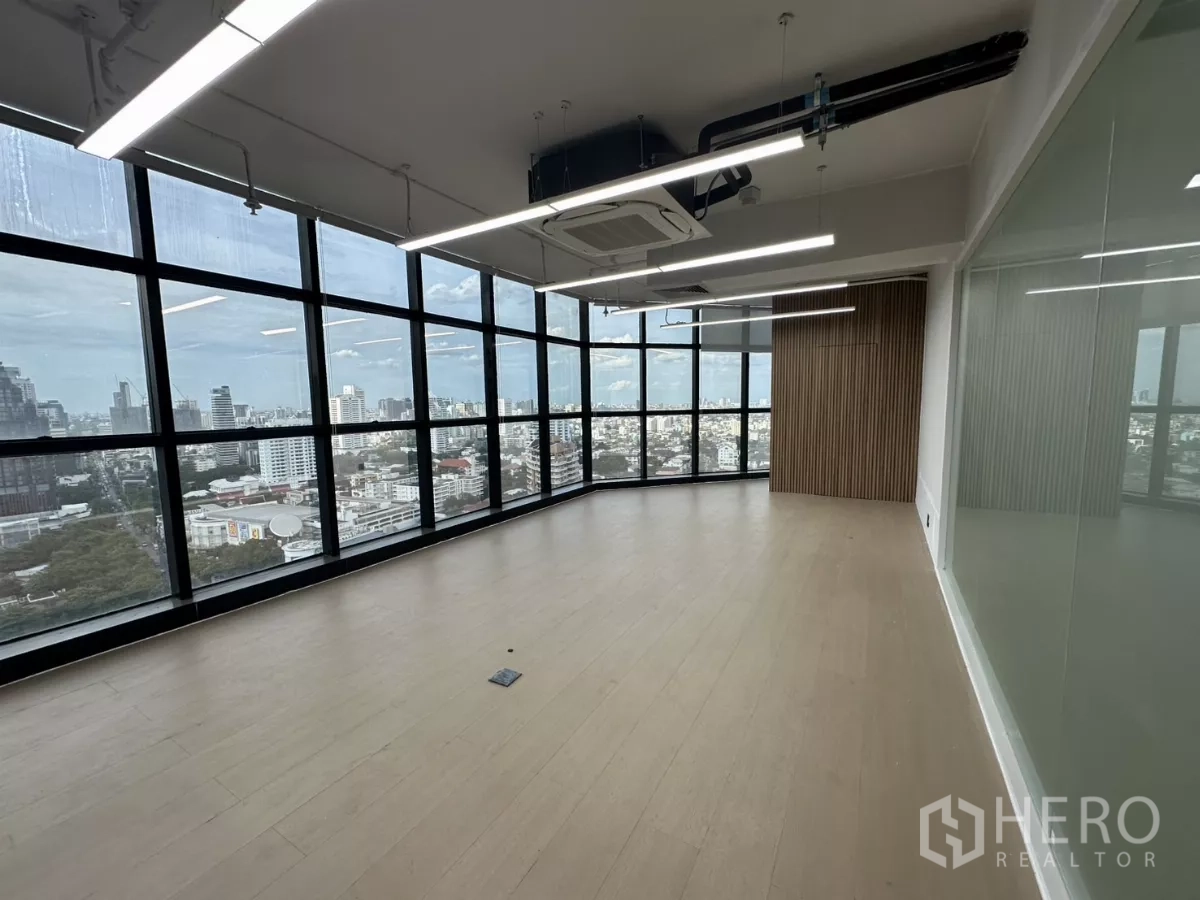 办公空间 出租在Watthana, Bangkok - 转角办公室，环景落地窗、城市景观与木饰墙。