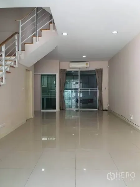 联排别墅 出租在Wang Thonglang, Bangkok - 明亮的客厅，地砖铺设，楼梯与推拉玻璃门