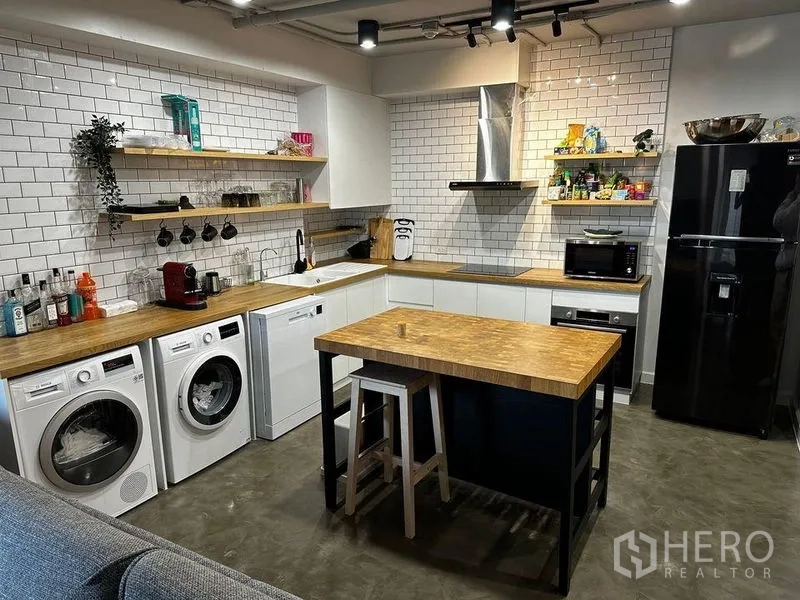 公寓 出租在Watthana, Bangkok - 设备齐全的厨房，含洗衣机、烘干机、洗碗机与中岛。