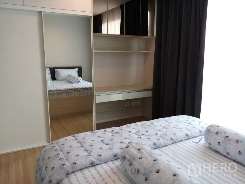 Townhouse for rent in Suan Luang, Bangkok - Bedroom with mirrored sliding wardrobe, built-in shelf and soft natural light.