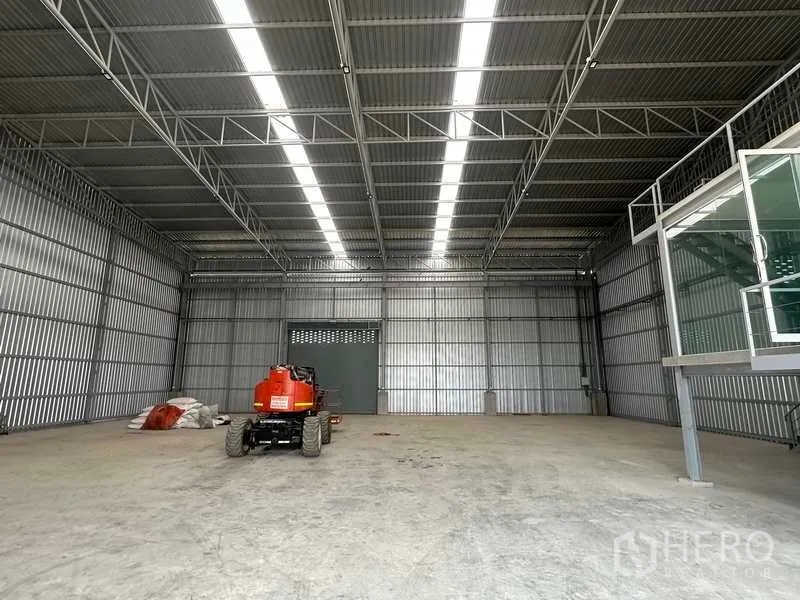 Factory for rent in Wang Noi, Phra Nakhon Si Ayutthaya - Clear-span warehouse floor with skylights and a boom lift parked inside.