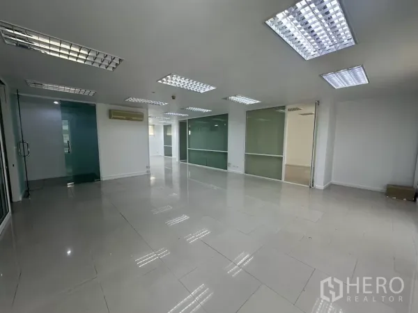 Office Space for rent in Huai Khwang, Bangkok - Large workspace with multiple glass meeting rooms and frosted partitions under grid ceiling lights.