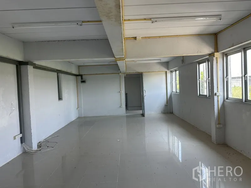 Factory for rent in Lam Luk Ka, Pathum Thani - Bright upper-floor office room with tiled floor and multiple windows.
