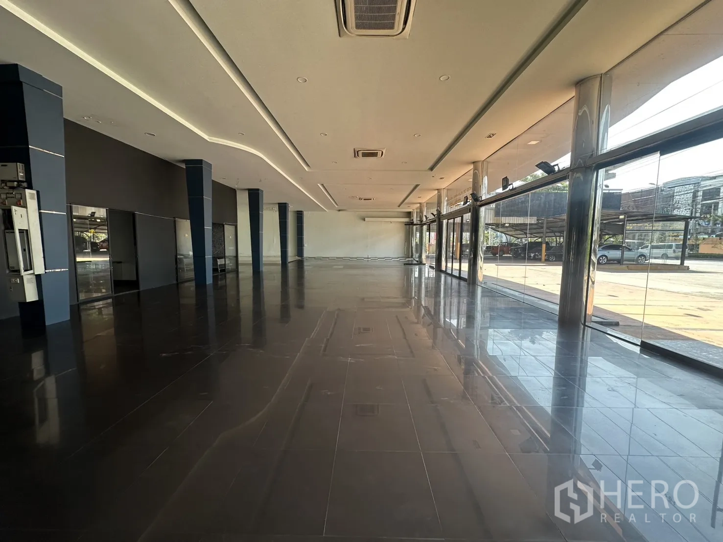 Showroom for rent in Suan Luang, Bangkok - Long sales floor lined with floor-to-ceiling windows and sliding glass doors.