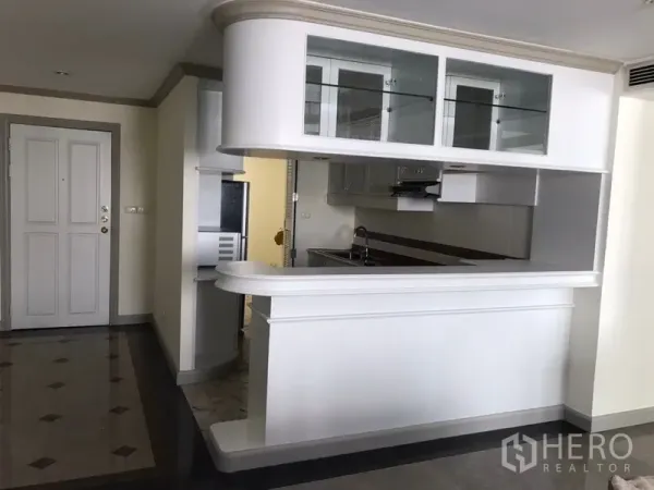 公寓 出租在Watthana, Bangkok - 半开放厨房，白色吧台与玻璃吊柜，不锈钢家电与操作台。