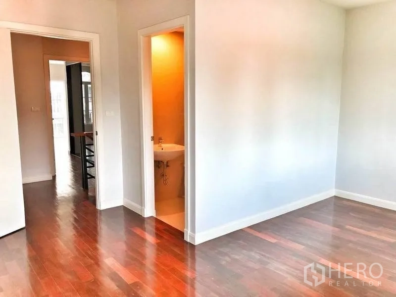 联排别墅 出租在Watthana, Bangkok - 明亮卧室一角，通往卫浴，木地板