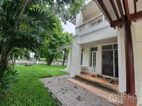 独立式住宅 出租在Lat Krabang, Bangkok - 前院草坪葱郁，成树成荫，带有覆盖式门廊的两层住宅。