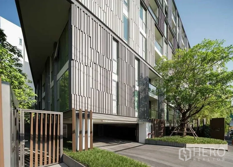 公寓 出租或出售在Watthana, Bangkok - 现代低层公寓外立面，竖向格栅设计，车道与大树景观。