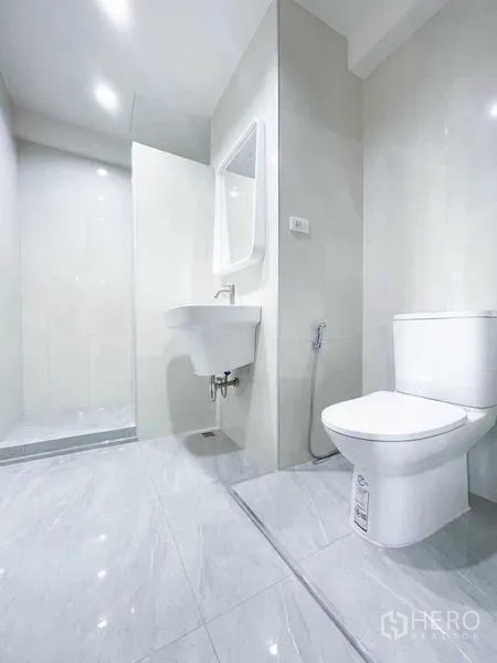 Condominium for rent or sale in Khlong Toei, Bangkok - Second bathroom with walk-in shower, vanity and glossy tile finishes.