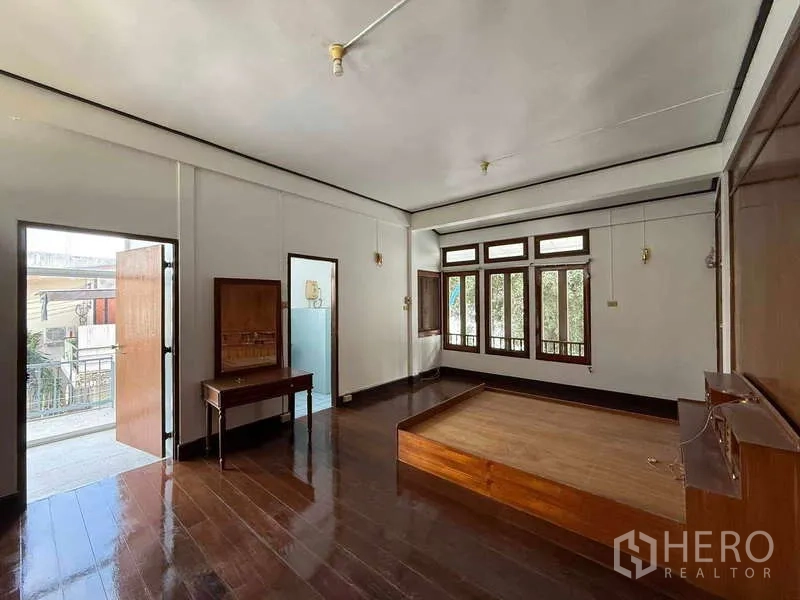 Detached House for rent in Watthana, Bangkok - Bright bedroom with wood floors, large windows and door to the balcony.