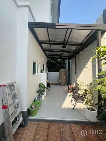 Detached House for rent in Bang Kapi, Bangkok - Covered utility area with tiled floor and potted plants.