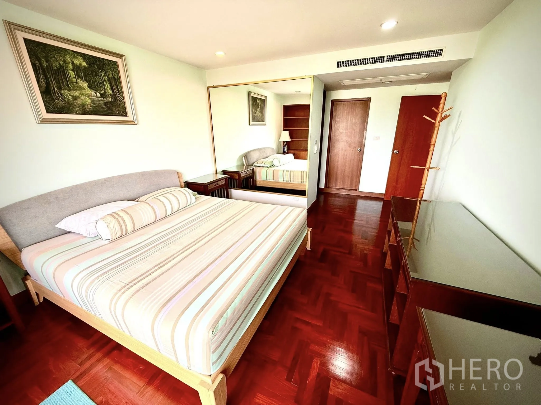 คอนโด ให้เช่าในSathon, Bangkok - ห้องนอนใหญ่ปูผ้าลายทาง มีโต๊ะข้างเตียงและตู้เสื้อผ้ากระจก.