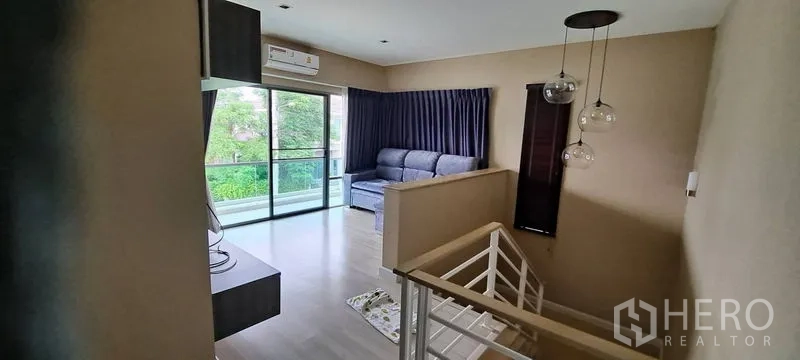Detached House for rent in Lat Krabang, Bangkok - Second-floor family lounge with balcony access and staircase feature lighting