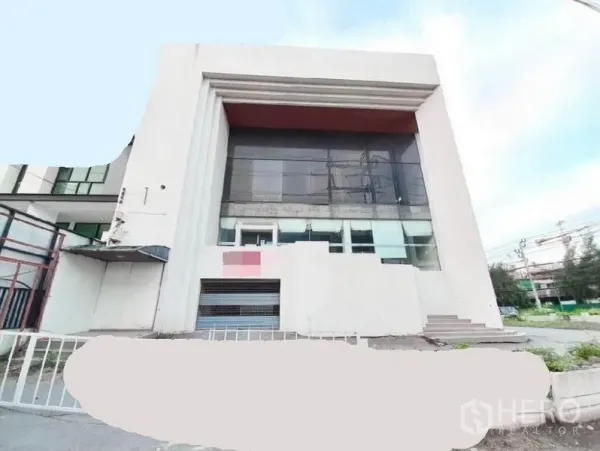 Shophouse for rent in Bang Na, Bangkok - Modern shophouse exterior in Bang Na with double‑height glass facade, wide front steps and roadside setting.