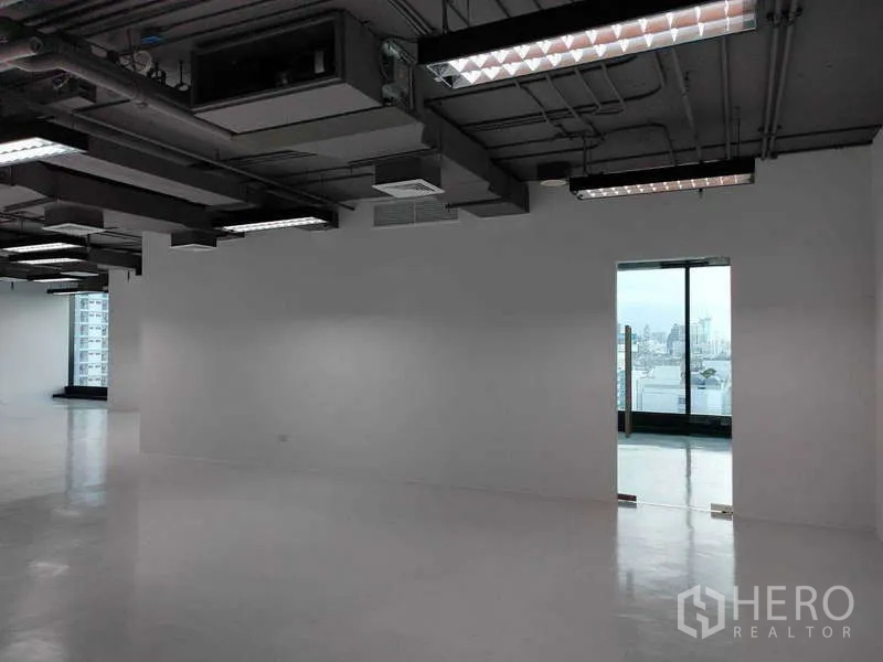办公空间 出租 - 宽敞办公室，悬挂灯具与通向城市景观的玻璃门。