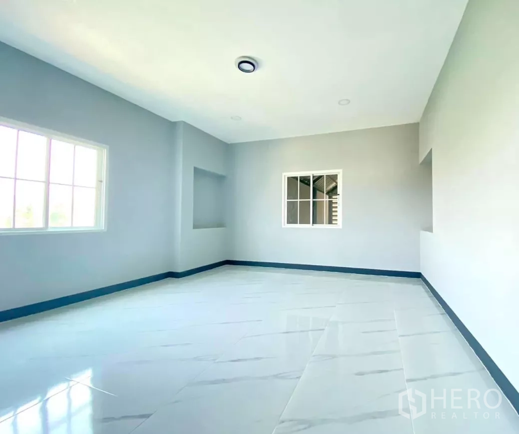 Factory for rent or sale in Bang Bua Thong, Nonthaburi - Spacious bedroom with wall niche and glossy white flooring.