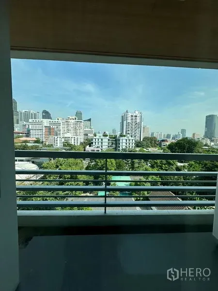 Apartment for rent in Khlong Toei, Bangkok - Balcony city view overlooking greenery and the Bangkok skyline.
