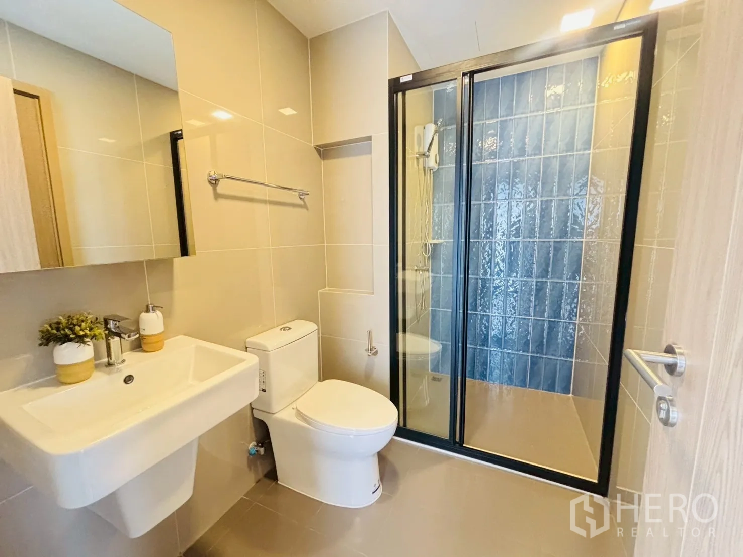 公寓 for rent in Watthana, Bangkok - 现代浴室，玻璃淋浴间、马桶与壁挂式洗手盆和镜子。