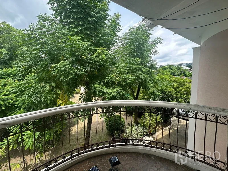 Detached House for sale in Phra Khanong, Bangkok - Upper-floor balcony view across leafy trees and a landscaped yard.