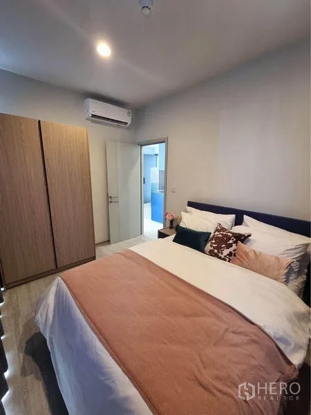 公寓 出租在Watthana, Bangkok - 温馨卧室，双人床、衣柜与空调，带通往浴室的门。