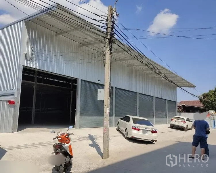 คลังสินค้า ให้เช่าในBang Kapi, Bangkok - ภายนอกโกดังผนังเมทัลชีท ทางรถกว้างและประตูม้วนหลายช่อง