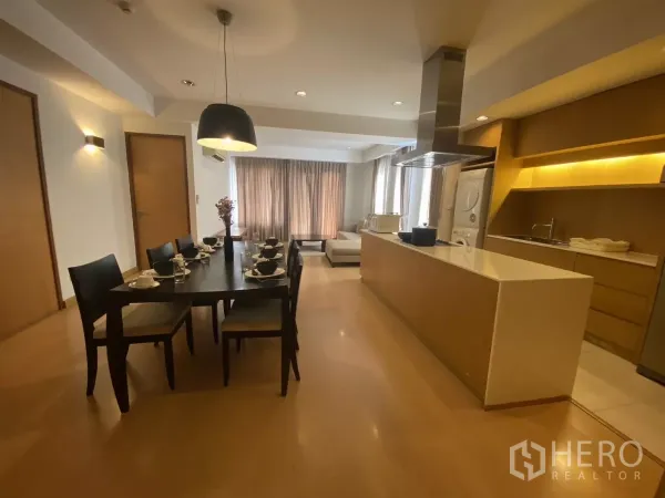 Condominium for rent in Watthana, Bangkok - Dining area for six beside a modern kitchen island and lounge, warm wood floors and pendant lighting.