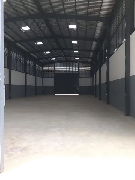 货栈 出租或出售在Nong Chok, Bangkok - 宽敞仓库内部，拱形高钢结构屋顶、混凝土地面与大型卷闸门。