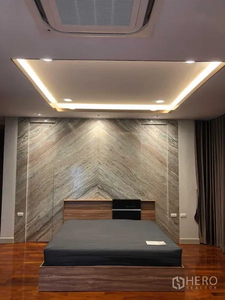 Detached House for rent in Bang Khae, Bangkok - Master bedroom with feature wall, recessed ceiling lighting and polished wood flooring.
