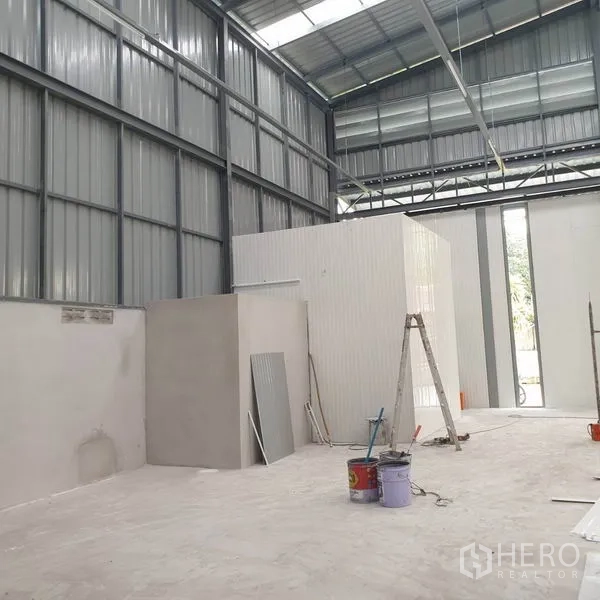 Warehouse for rent in Khlong Toei, Bangkok - Warehouse interior with small office module under construction and ladder.
