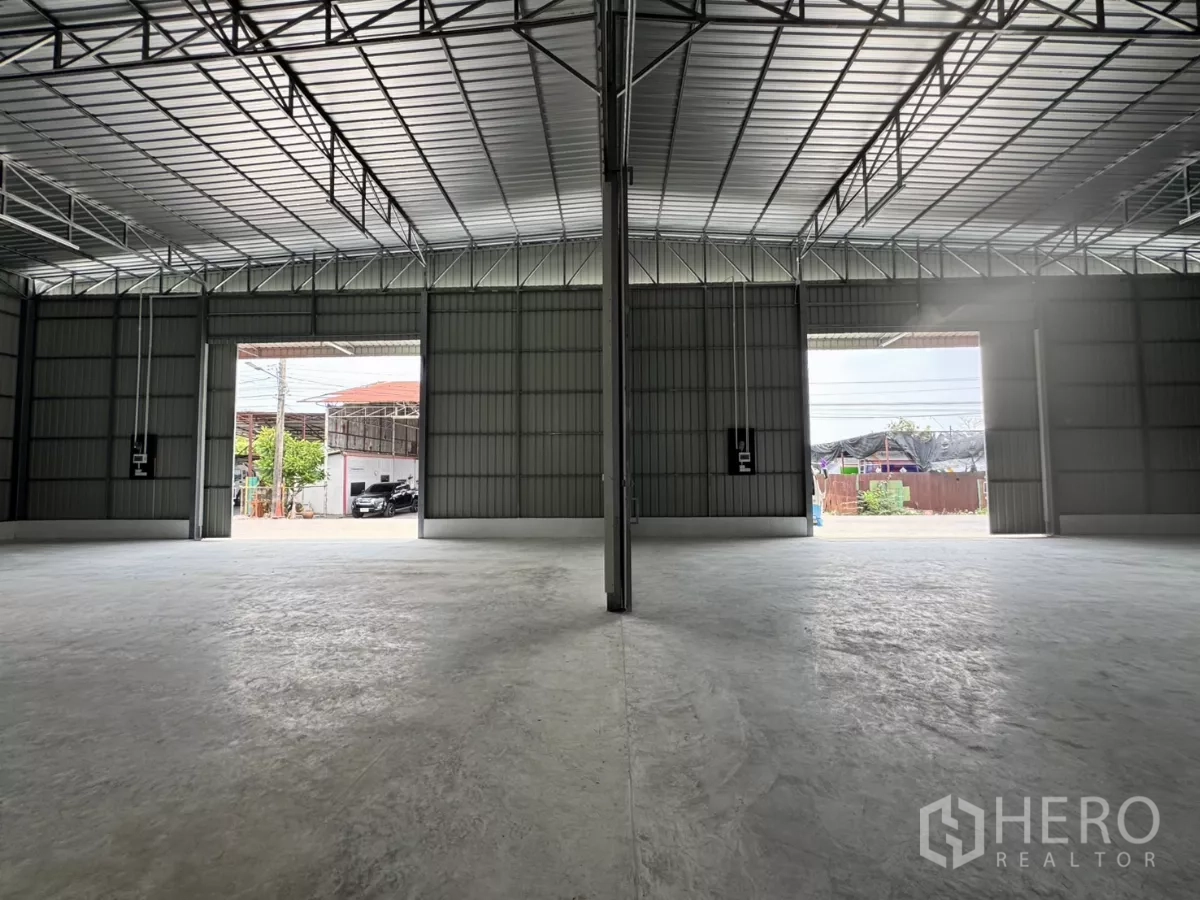 Warehouse for rent in Lam Luk Ka, Pathum Thani - Interior outlook toward two large door openings providing natural light and easy loading.
