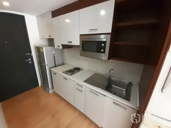 公寓 出租在Pathum Wan, Bangkok - 现代一字型厨房，白色柜体、微波炉、灶台、水槽与冰箱