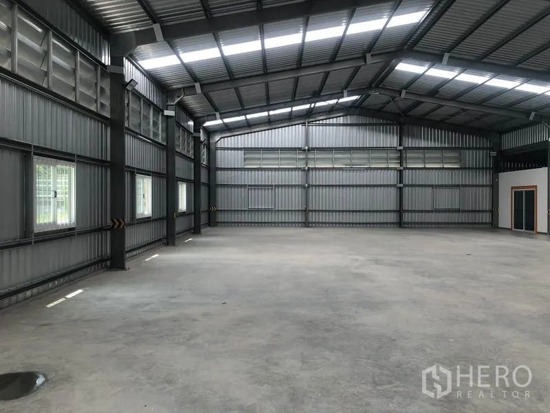 Warehouse for rent in Mueang Nonthaburi, Nonthaburi - Wide interior angle showing windows, louvered vents and clear-span floor space.