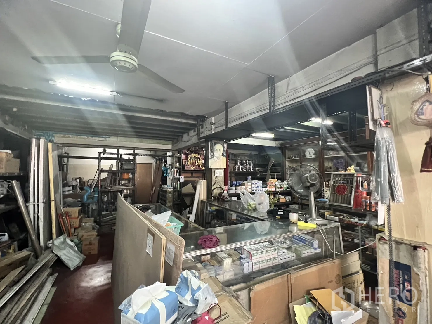 Retail Space for rent in Watthana, Bangkok - Retail interior with glass display counter, ceiling fan and steel racks holding hardware supplies.
