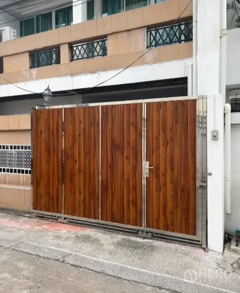 联排别墅 出租在Khlong Toei, Bangkok - 曼谷瓦他那区联排别墅的木质推拉门入口。